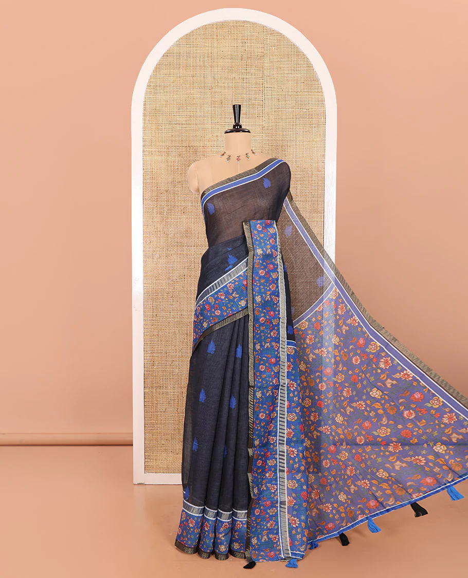 Black Linen Saree Adorned with Leaf Motifs All Over Its Body, Complemented by a Contrast Floral Vine Printed Border, Pallu Mirrors the Floral Vine Print, and Paired with a  Contrast Floral Printed Blouse