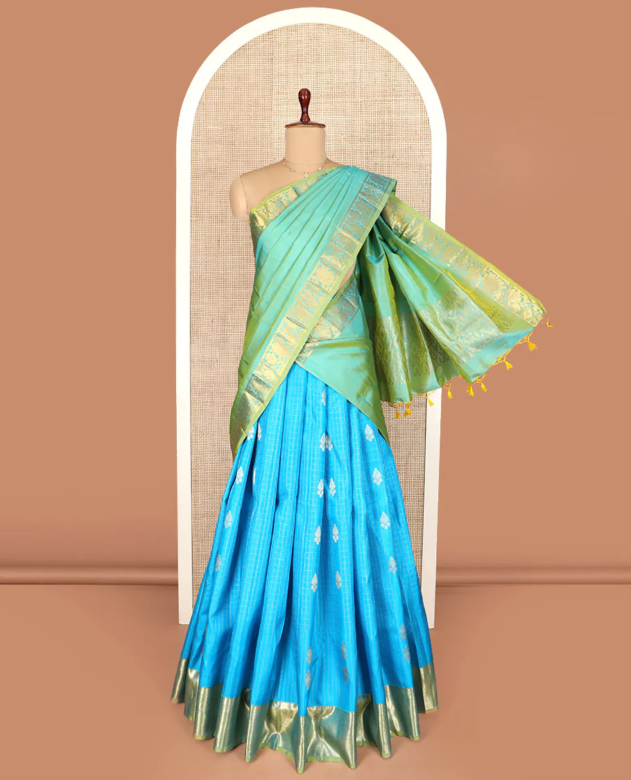 Blue Pure Silk Half-Saree Adorned with Zari Buttas Enclosed in Checks on the Skirt, Complemented by a Contrast Border Featuring Thilakam Mokku, Arumbu Manga, and Mayil Kann Designs, Paired with a Contrast Blouse, and a Jaal Design Dhavani