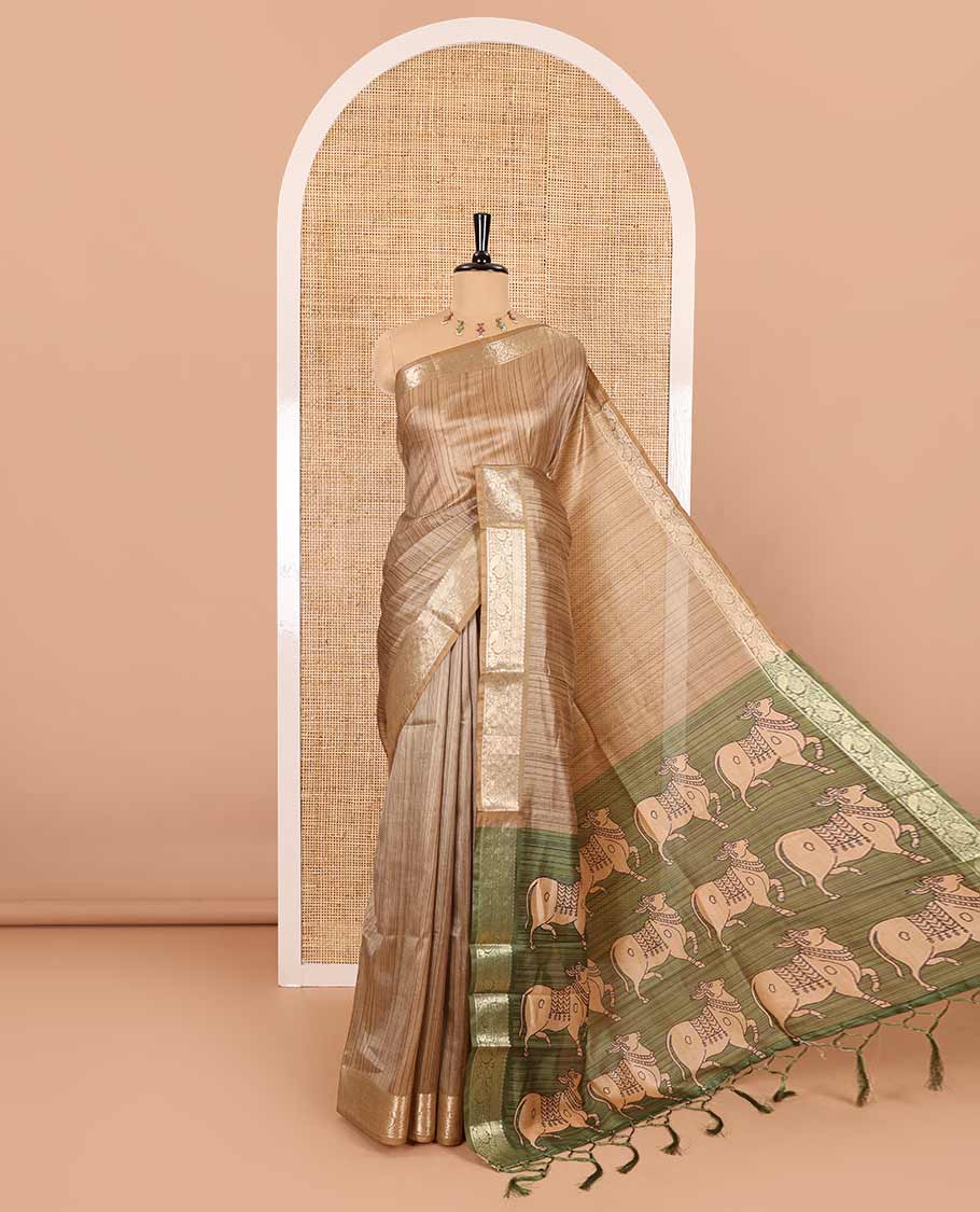 Chikku striped semi-tussar saree, traditional zari border of floral creeper designs, contrast pallu of Pichwai cow print, and contrast Pichwai cow printed blouse