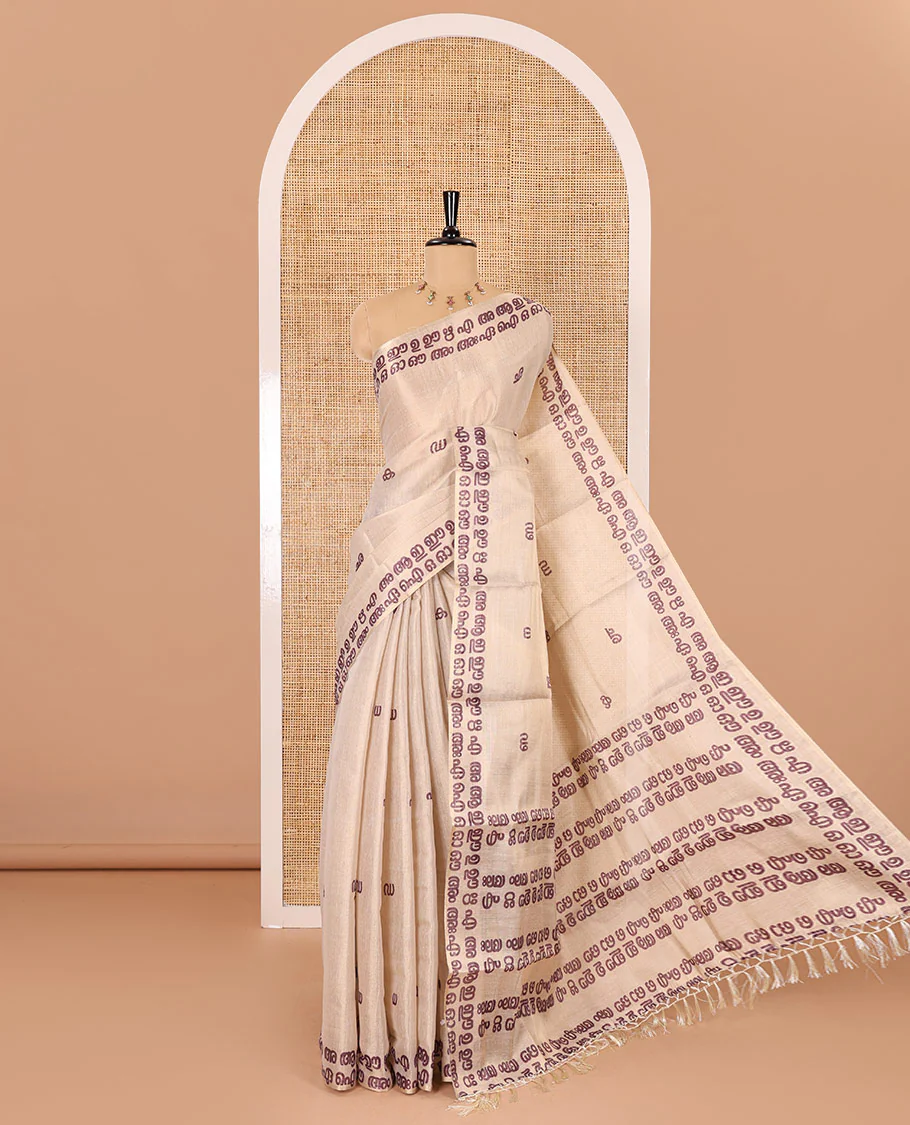Cream-magenta Malayalam letter printed tissue saree, self-border and pallu steeped with Malayalam letter motifs, and a contrast plain blouse