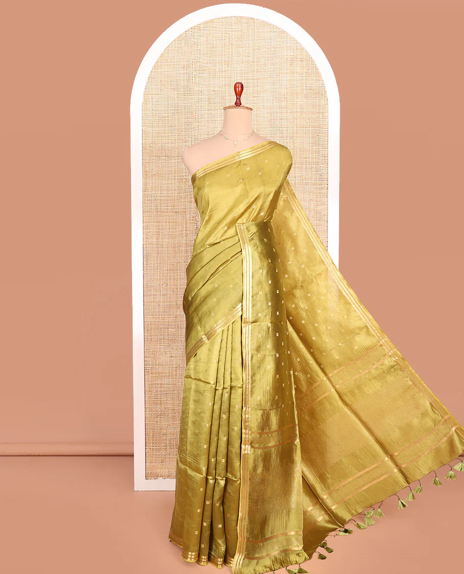 Green Banana Pith Saree Gracefully Embellished with Square-Shaped Zari Buttas, Subtly Woven Zari Piping Border, Pallu Gleamed Up with Zari Stripes, and Paired with a Matching Blouse