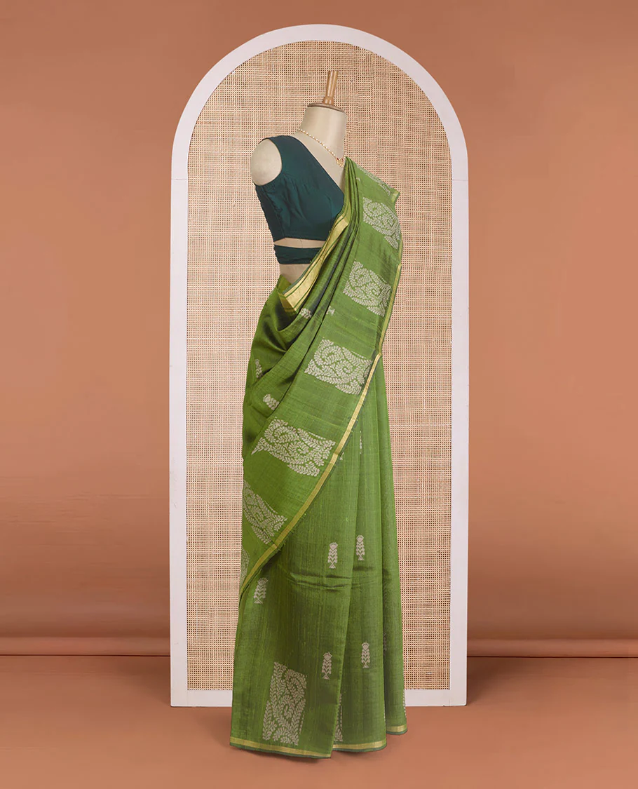 Green dupion silk saree with floral buttas, thin zari piping border, and floral vine pallu