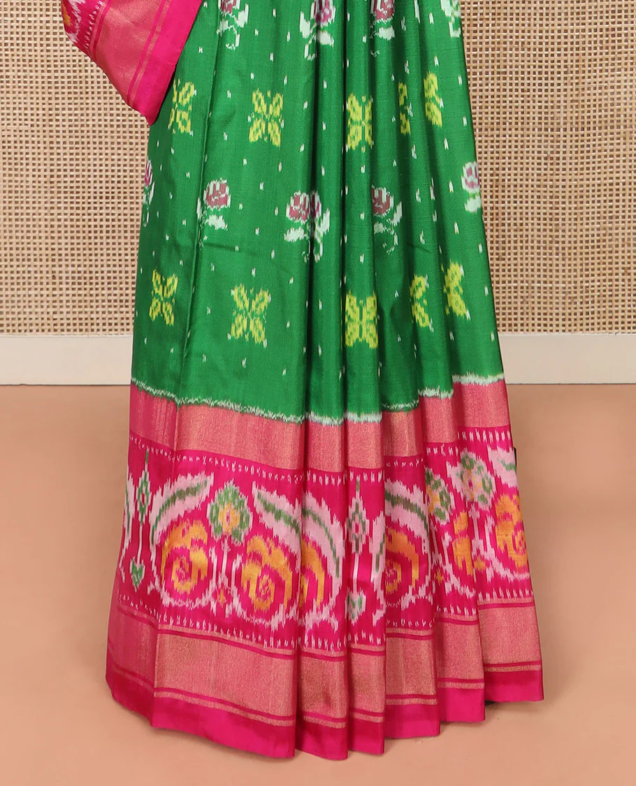 Green Ikkat silk saree features floral Ikkat buttas, highlighted with a contrast Ikkat woven border, a hazily woven Ikkat patterned pallu, and a contrast blouse - Image 4