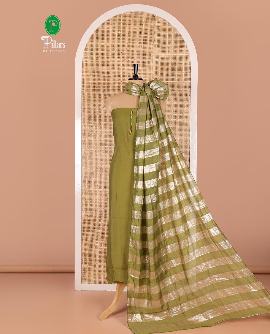Green material chudidar set, plain with pom-pom tasseled mul chanderi top, a matching bottom, and organza dupatta of stripes