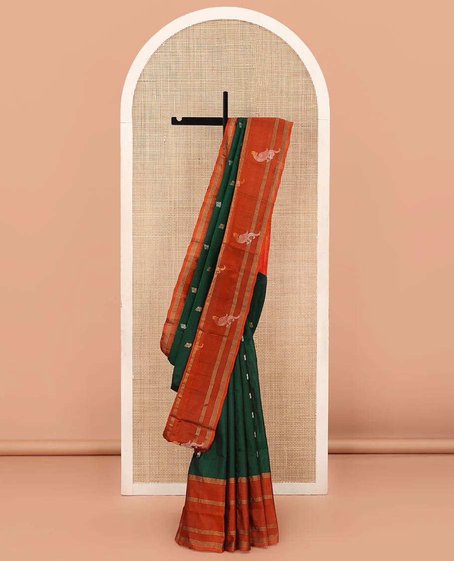 Green Uppada Silk Saree Enlivened With Zari Buttas, Captivating Contrast Border Featuring Zari Stripes And Peacock Motifs, Pallu Depicting Rose Flower-Enclosed Mughal-Style Arches, And Paired With A Contrast Blouse