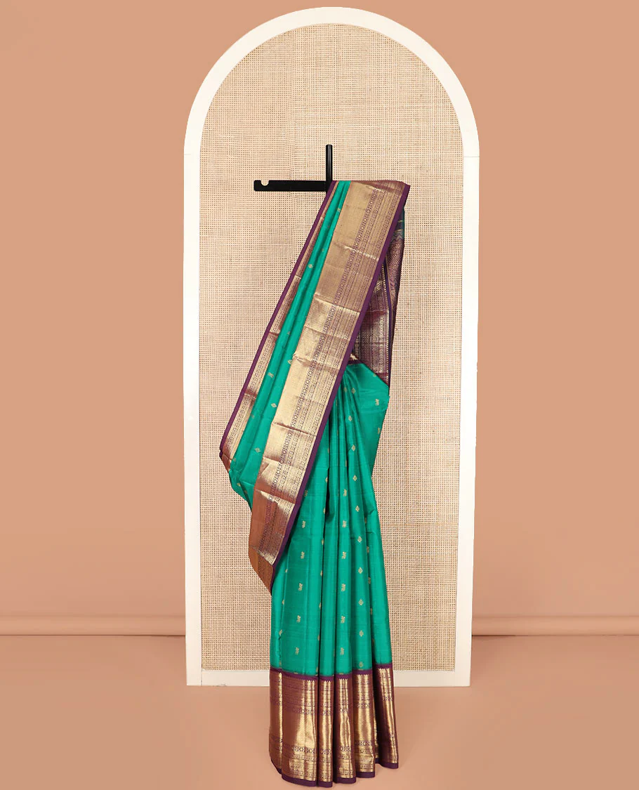 Green Vasundhara Silk Saree Subtly Sparked with Zari Buttas, Highlighted with a Contrast Big Zari-Decked Traditional Motifs Woven Border, Pallu Steeped with Traditional Zari Designs, and Paired with a Contrast Blouse