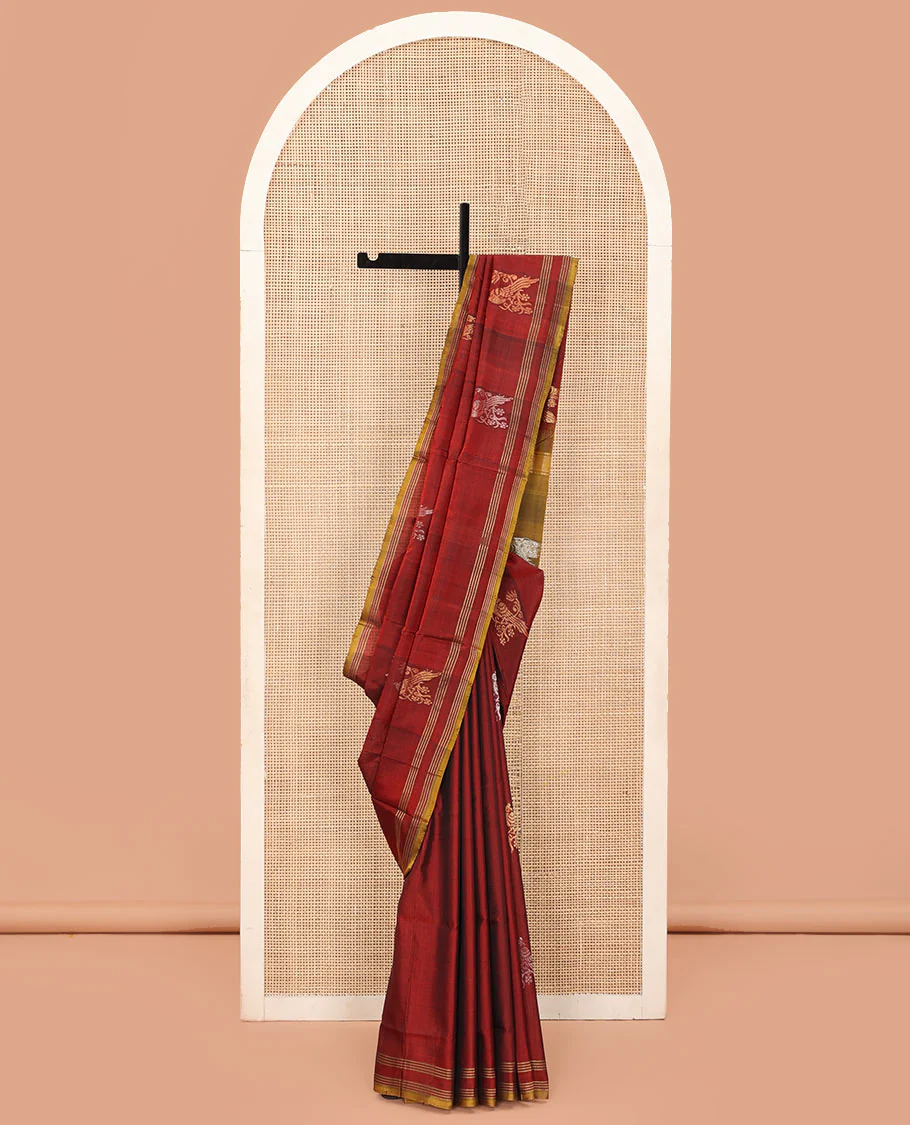 Maroon Uppada Silk Saree Embellished with Parrot Zari Buttas, Highlighted with a Contrast Piping Border, Pallu Decked Up with Zari Designs, and Paired with a Contrast Blouse