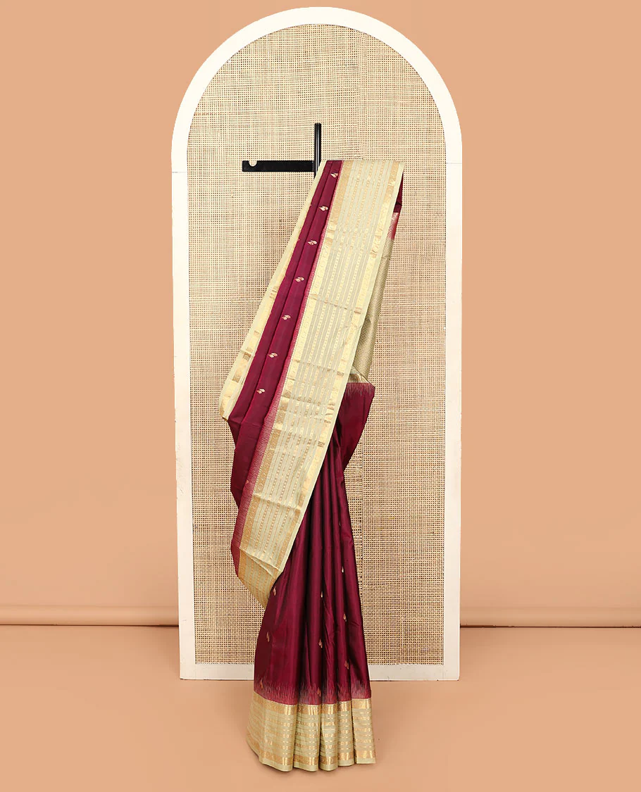 Maroon zari buttas Vasundhara silk saree, contrast varisai pettu border of rekku, kamalam, banaras, and diamond designs, and jaal pallu