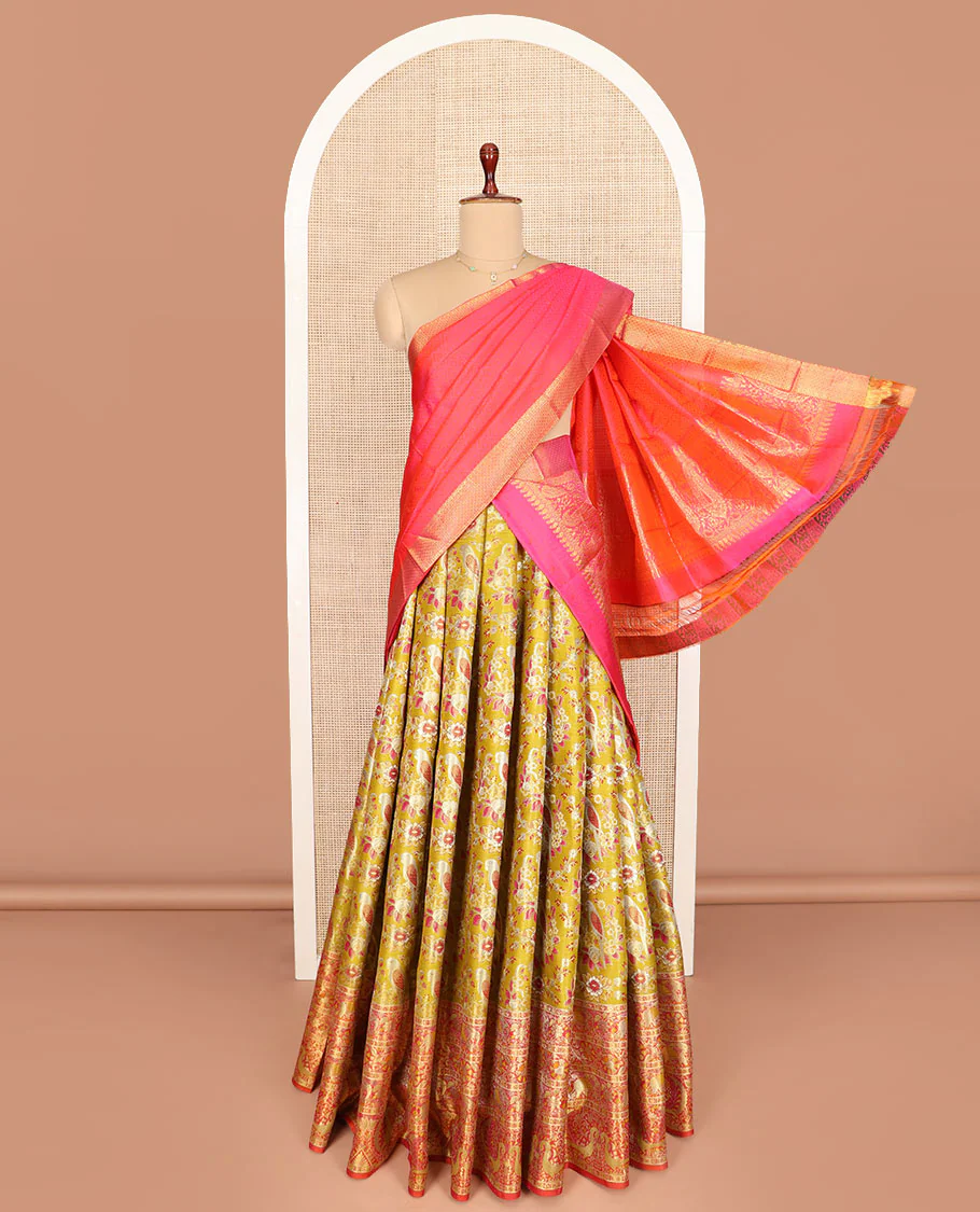 Mustard Art Silk Half-Saree Richly Detailed with Parrot Jacquard Designs on Its Skirt, Featuring a Finely Crafted Meenakari Border of Yaanai and Mayil Motifs, Paired with a Zari-Enriched Jacquard Blouse, and Complemented with a Manga-Designed Dhavani