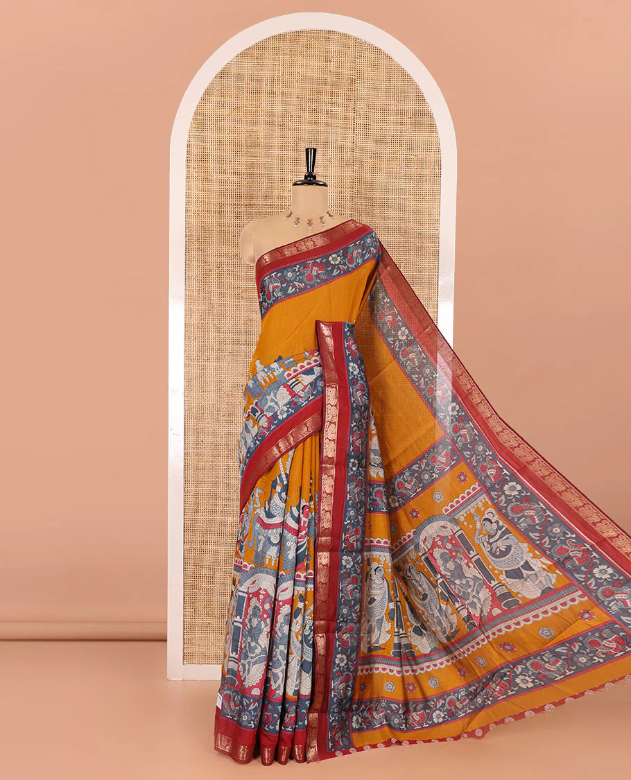 Mustard kalamkari ancient human figurines machine-printed muslin cotton saree, contrast traditional design zari border, kalamkari printed pallu, and contrast floral motifs and zari bordered blouse