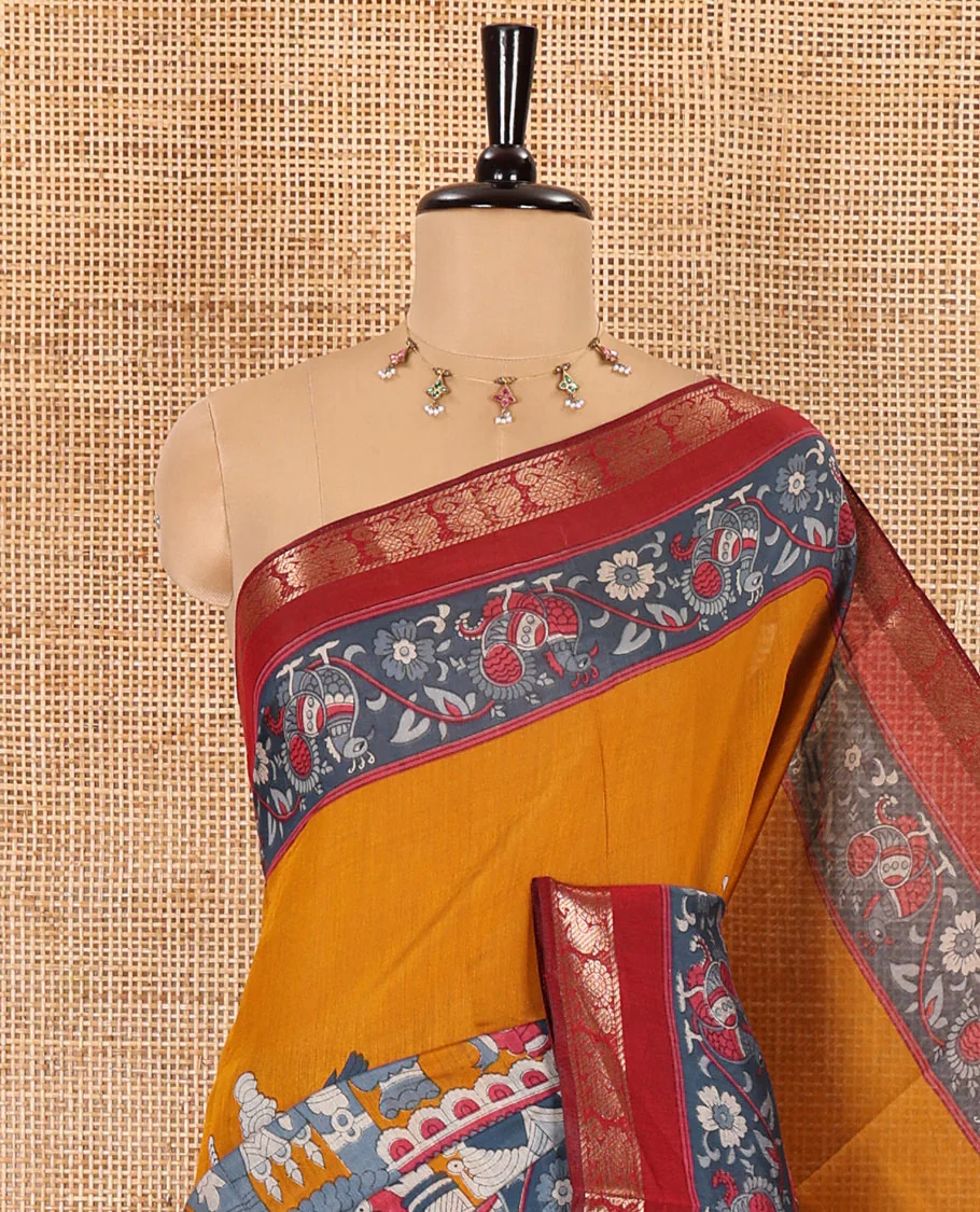Mustard kalamkari ancient human figurines machine-printed muslin cotton saree, contrast traditional design zari border, kalamkari printed pallu, and contrast floral motifs and zari bordered blouse - Image 2
