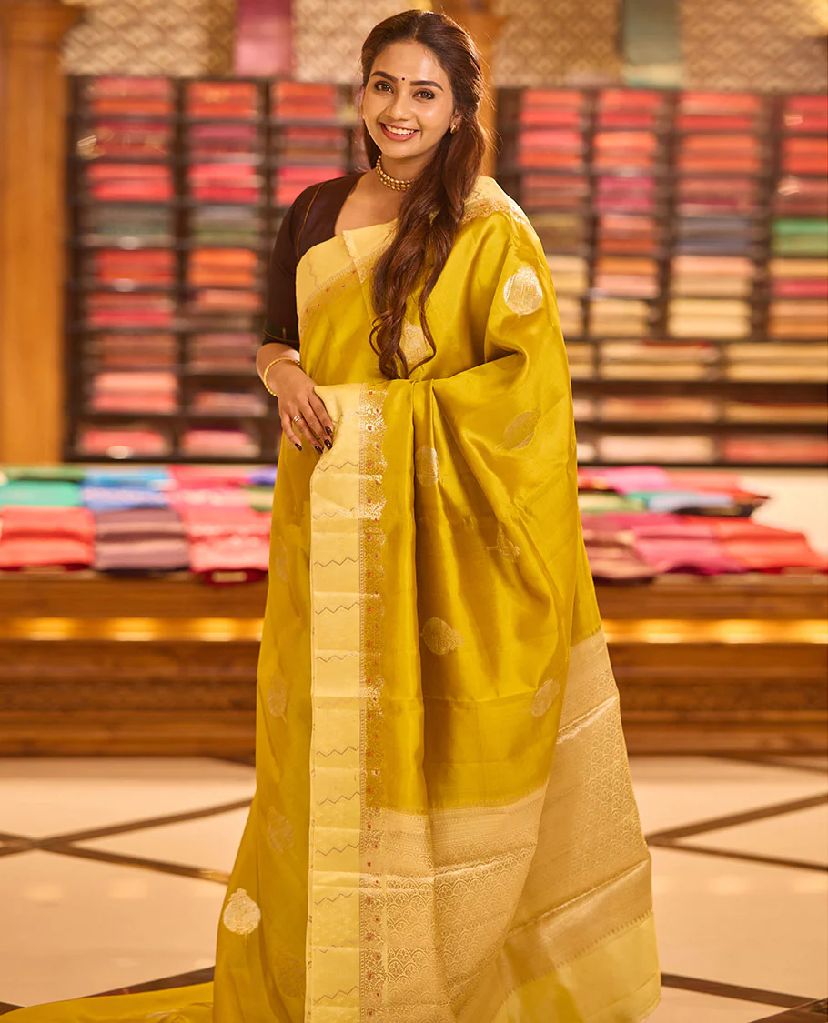 Mustard unblossomed flower-shape zari buttas raw mango silksaree,satin embossed border of meenakari zari floral vine & scallop jacquard pallu