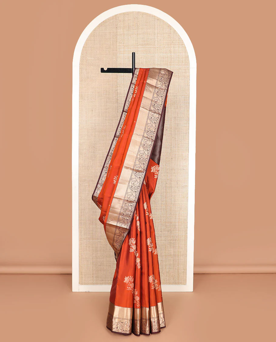 Orange floral buttas Vasundhara silk saree, contrast border of rekku, mayil kann, and mayil designs, and chevron striped pallu