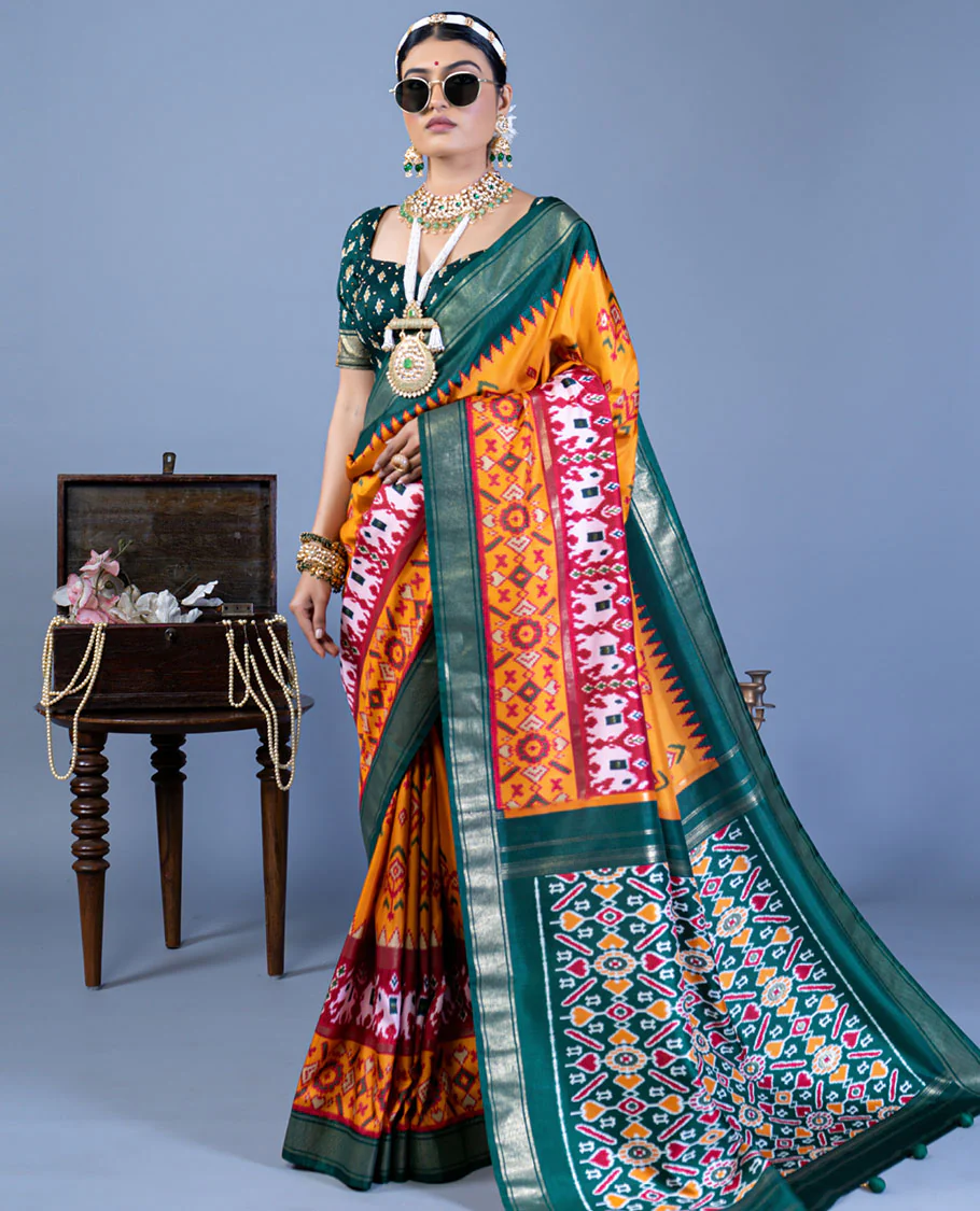 Orange patola floral motifs designer saree, contrast temple border, and patola printed pallu