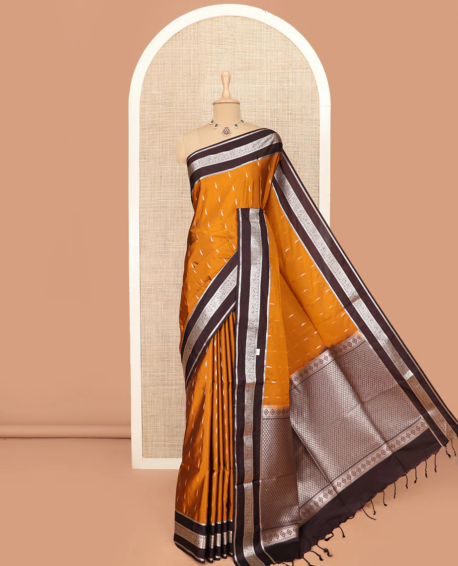 Orange Semi-Soft Silk Saree Graced with Zari Buttas Woven Across Its Body, Complemented by a Contrast Varisai Pettu Traditional Zari Border, Grandly Decked Up Pallu of Jaal Designs, and Paired with a Contrast Blouse