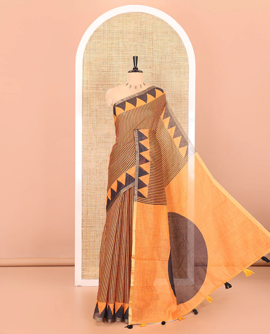 Orange vertical stripes printed linen cotton saree, a temple-printed border, big polka dot printed pallu, and a printed blouse