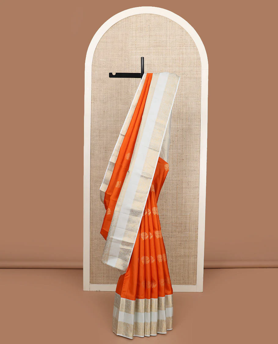 Orange zari buttas Vasundhara silk saree, contrast rettai pettu border of thilakam mokku, kamalam, and mayil designs, and jaal pallu