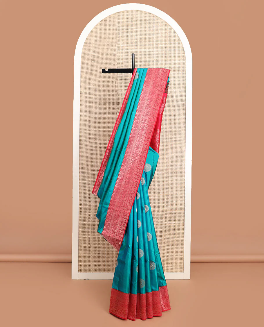 Peacock blue charkam buttas Vasundhara silk saree, contrast border of thilakam mokku, neli, kamalam, kathir, floral, and diamond designs, and Mughal floral woven pallu