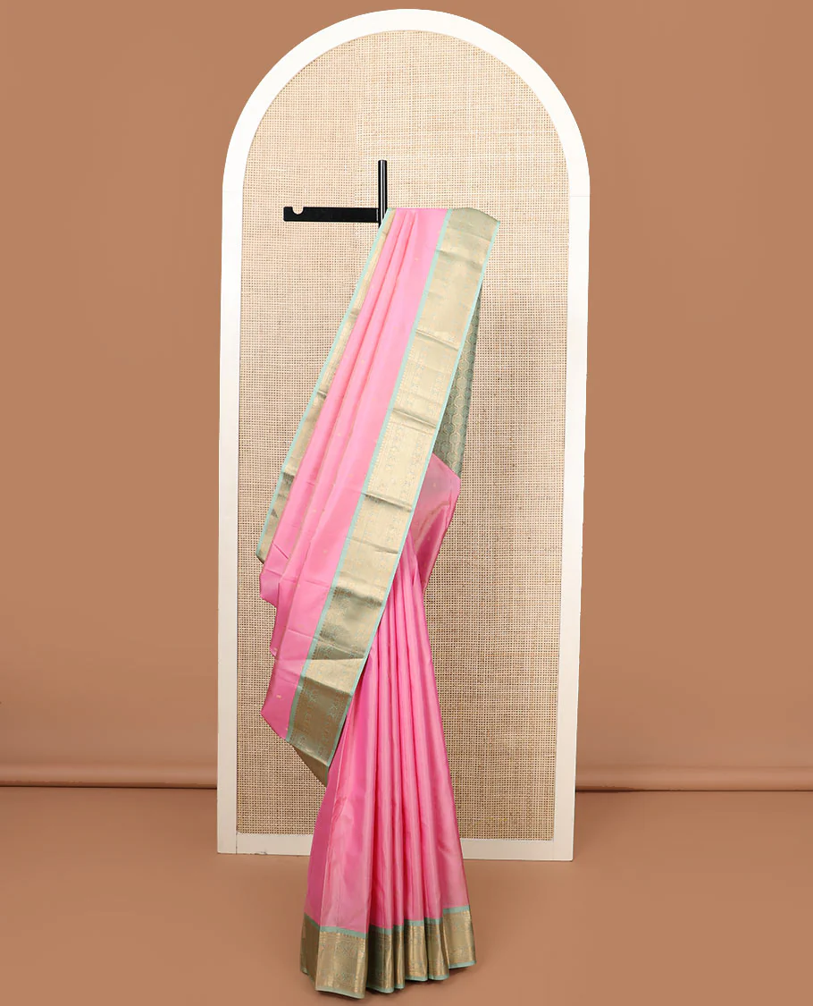 Pink zari buttas Vasundhara silk saree, contrast border of thilakam mokku, jaal, manga, and mayil designs, and Mughal-style intricate pallu