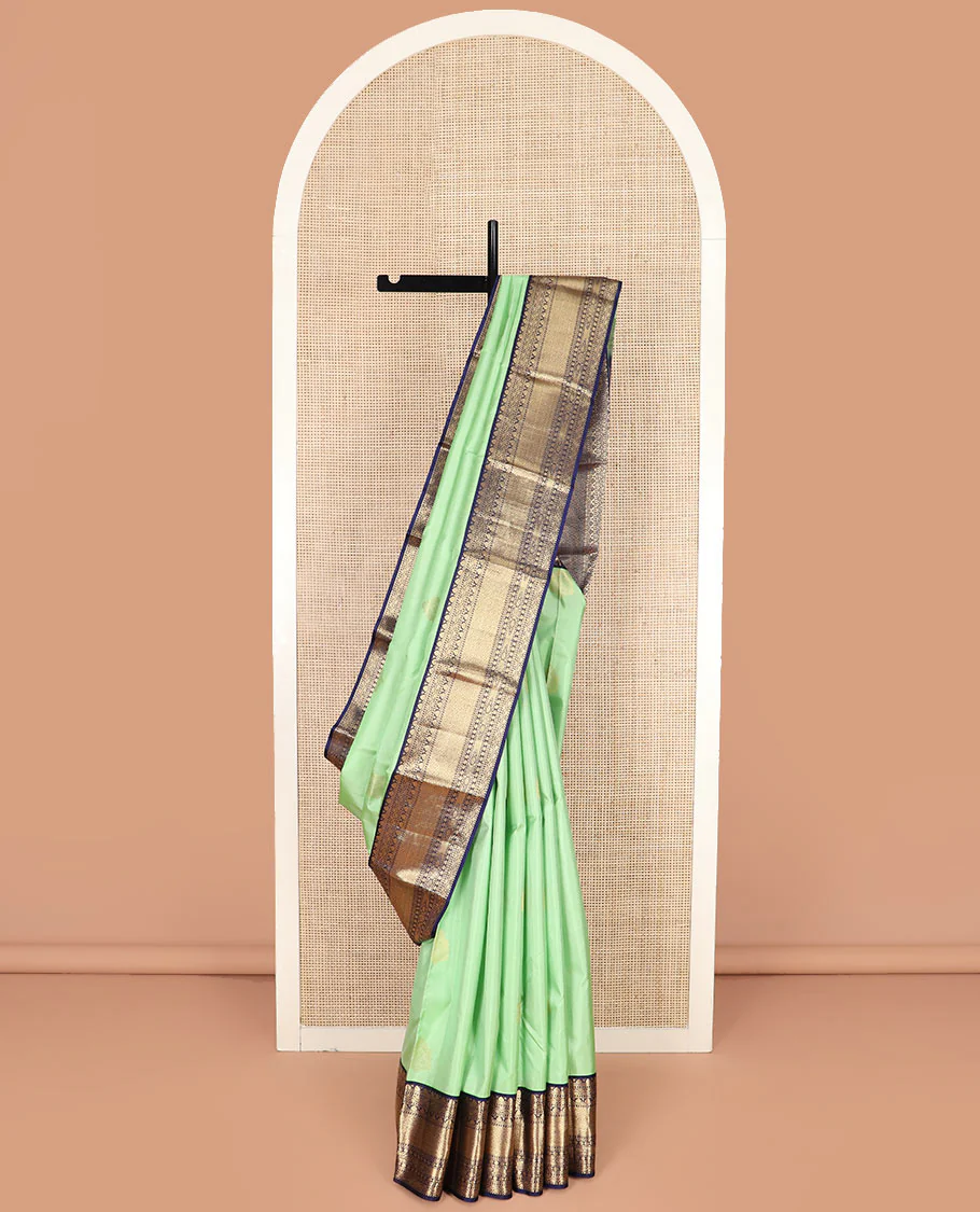 Pistachio Green Vasundhara Silk Saree Elegantly Embellished with Zari Buttas, Complemented with a Contrast Border Featuring Thilakam and Mayil Kann Designs, Majestically Detailed Pallu of Intricate Designs, and Paired with a Contrast Blouse