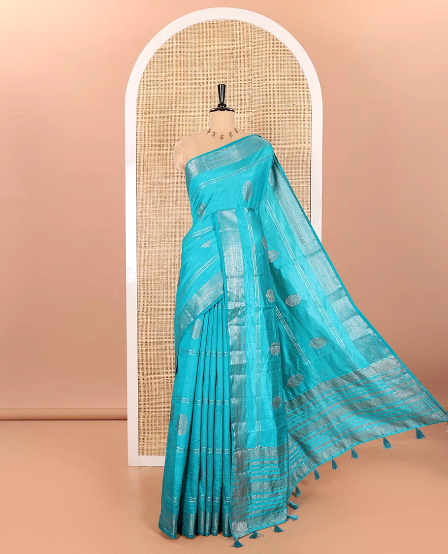 Rama Semi-Tussar Saree Accentuated with Gold Zari Stripes and Elegant Paisley Zari Buttas, Featuring a Subtly Shimmering Pallu Adorned with Traditional Zari Designs, and Paired with a Matching Blouse
