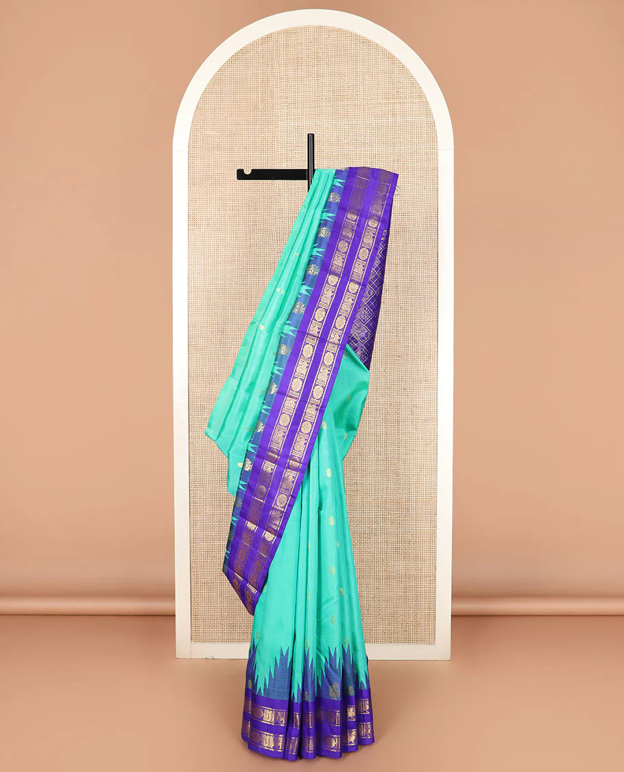 Turquoise zari buttas Kanchipuram silk saree, contrast thazampoo rekku rettai pettu border of annam chakram designs, and zari-rich jaal pallu