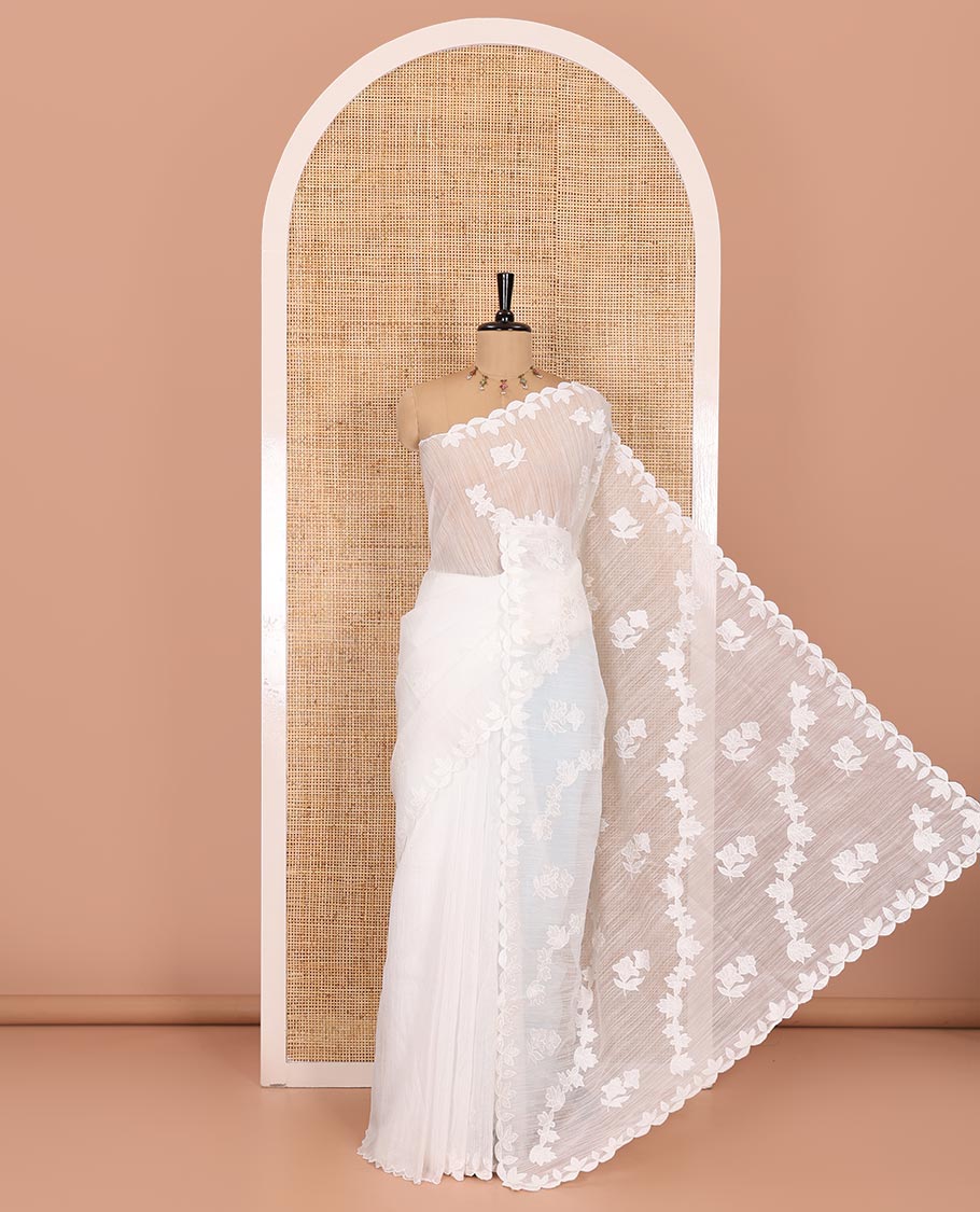 White floral motifs and diagonal floral creeper applique embroidered linen saree, scallop border, floral embroidered pallu, and a plain blouse