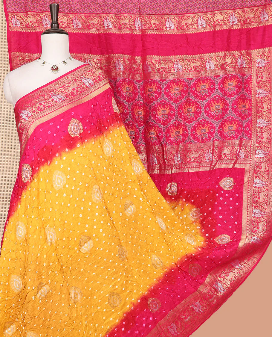 Yellow bandhani dots and zari buttas bandhani silk saree, contrast flora-fauna motifs woven border, and patola elephant enclosed ogee patterns