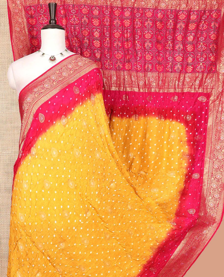Yellow bandhani dots and zari buttas bandhani silk saree, contrast floral creeper zari border, and patola-style butta enclosed checked pallu
