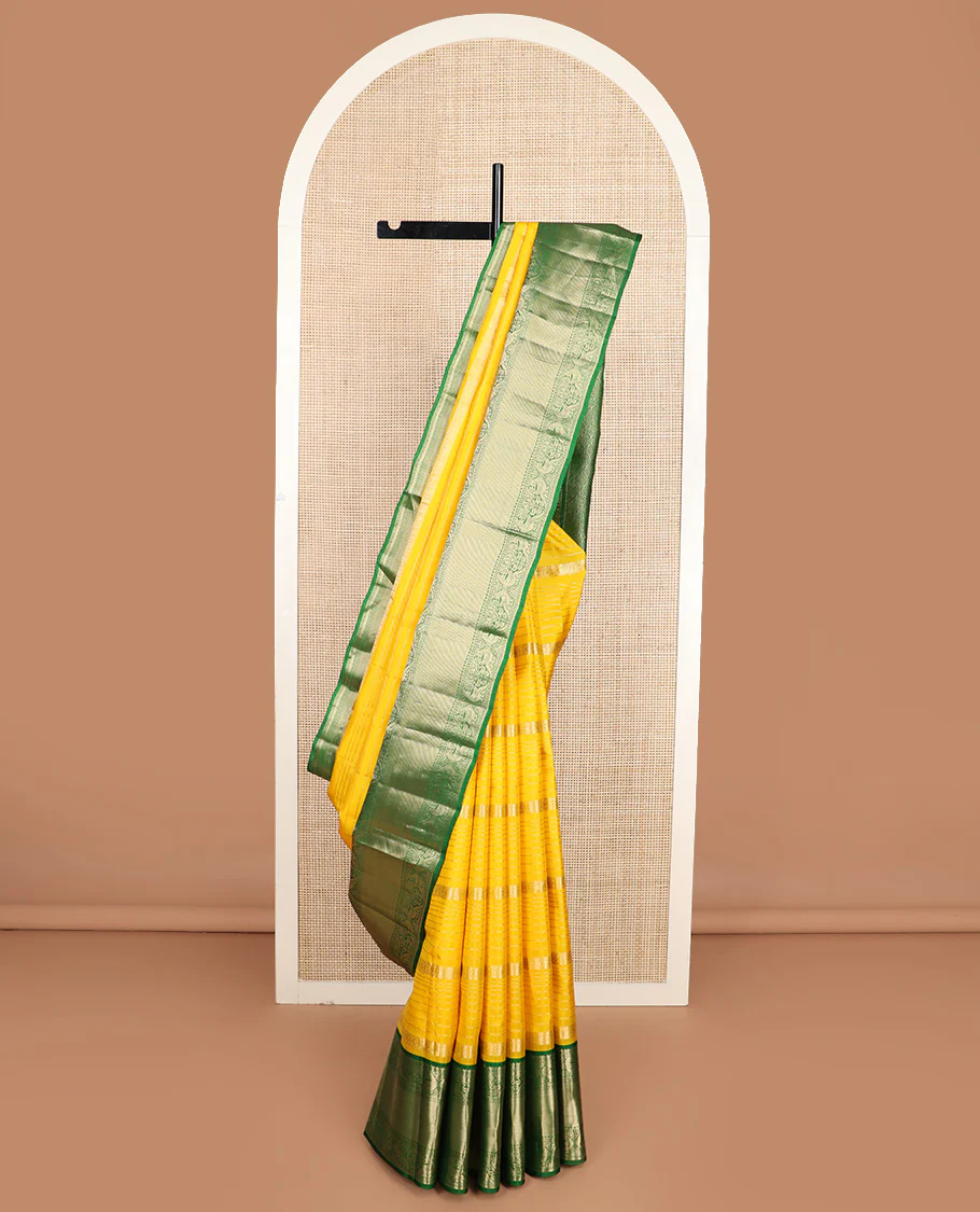 Yellow zari design Vasundhara silk saree, contrast border of reeku, lavangam, and kili designs, and ogee patterned pallu
